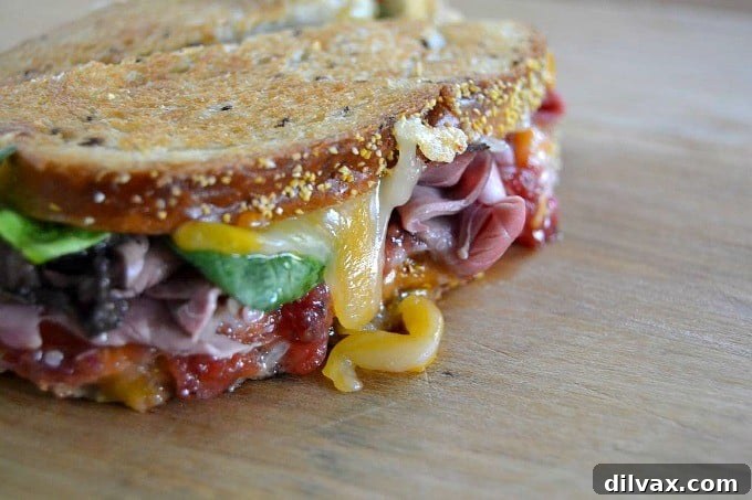 Layers of Wisconsin cheddar and gouda cheeses, caramelized onions, plum chutney and roast beef make up this incredible grilled cheese sandwich!