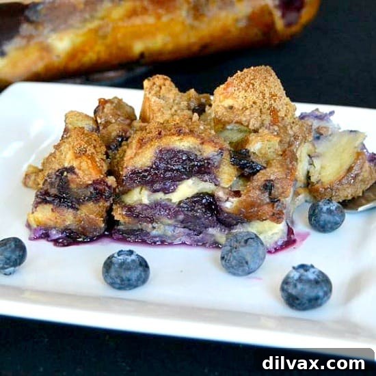 Sweet Blueberry Bagel Casserole 9 A slice of Blueberry Bagel Breakfast Bake, garnished with fresh blueberries