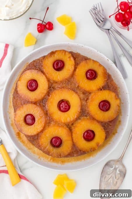Caramelized Pineapple Flip Cake 8 Pineapple Upside Down Cake with cherries on a yellow cake.