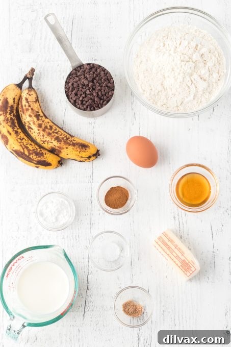 Banana Chocolate Scone Delight 4 An organized display of all the fresh ingredients needed for baking Banana Chocolate Scones: flour, butter, ripe bananas, eggs, honey, buttermilk, and chocolate chips, alongside warming spices.