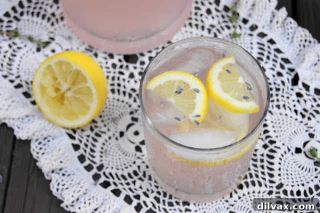 Lavender Lemonade, a pale purple drink garnished with lavender sprigs and lemon slices.