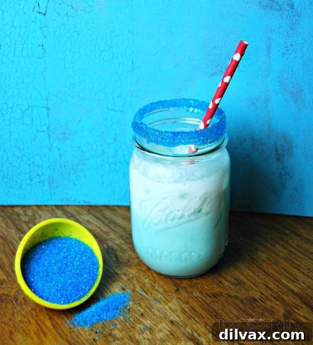 Blue Pixie Dust Lemonade, a vibrant blue drink with a shimmering effect, garnished with lemon slices.