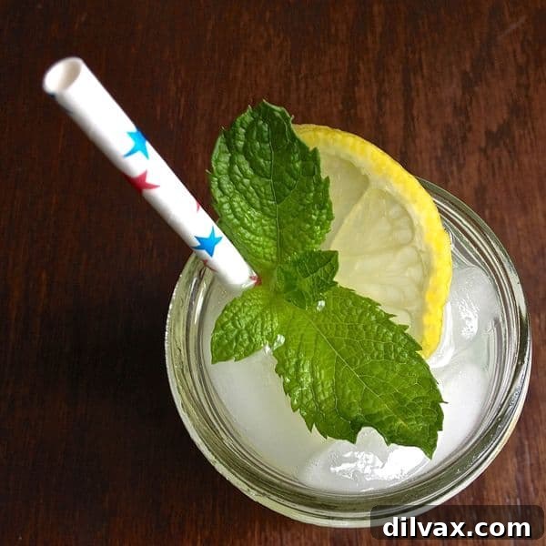 Sparkling Orange Blossom Water Lemonade, a light drink with a subtle floral aroma, garnished with orange slices.