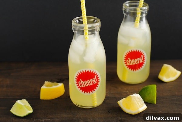 Agave Lime Lemonade, a light green drink garnished with lime and lemon slices, sweetened with agave.