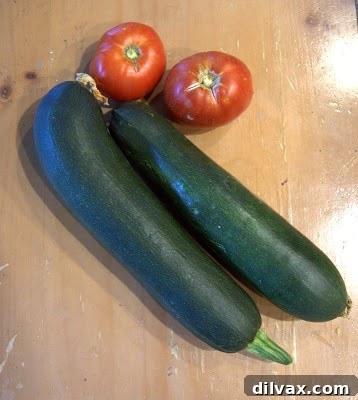 Savory Stuffed Zucchini 2 Freshly harvested zucchini and tomatoes from a home garden, bathed in natural light.