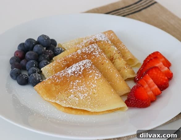 My family absolutely loves this Easy Crepe Recipe and yours will, too. Simply made with flour, eggs, milk and a little sugar, these thin French crepes or pancakes can be enjoyed a variety of ways. My favorite way to eat them is warmed with some pure maple syrup, but they're delicious with fillings, too!