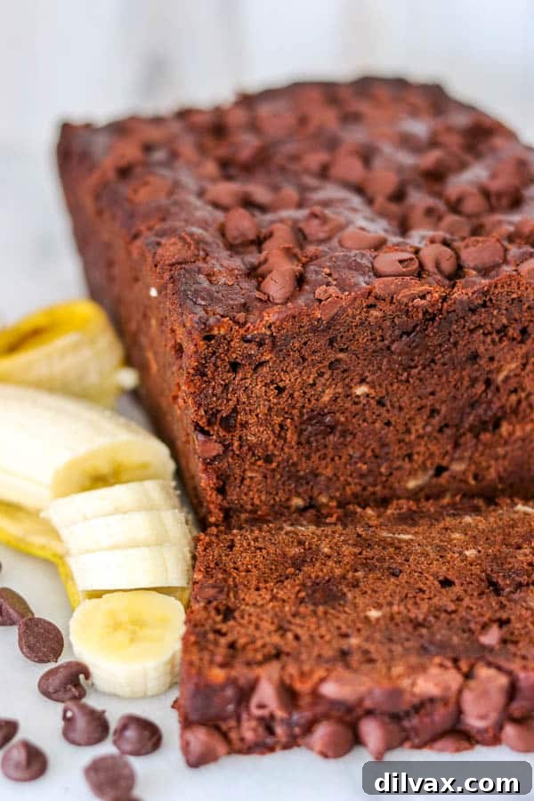 Decadent Double Chocolate Banana Loaf 3 A high-angle shot of a baked Double Chocolate Banana Bread loaf on a wooden surface, showing its dark, rich color and visible chocolate chips.