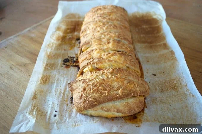 Twisted Taco Bake 7 A slice of Taco Braid on a plate, showing the layers of filling and golden crust, with a side of fresh toppings and dips.