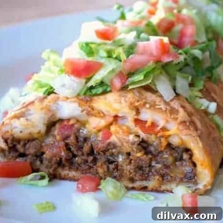 Taco seasoned ground beef, cheese, and tomato rolled in a pizza dough, ready to bake.
