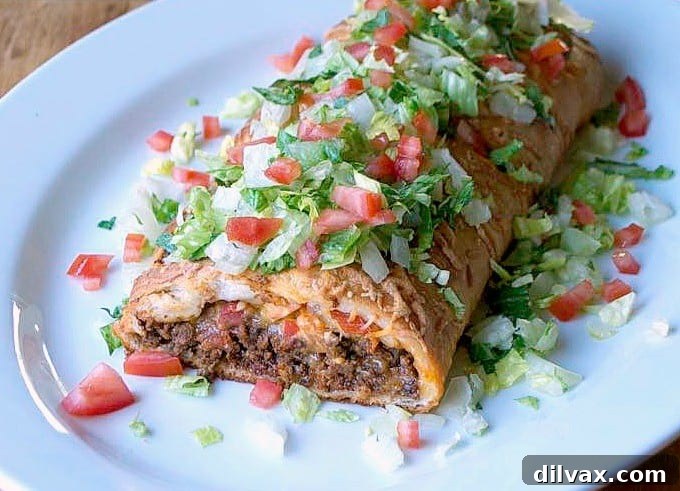 A freshly baked Taco Braid, sliced and ready to be served, topped with fresh lettuce.