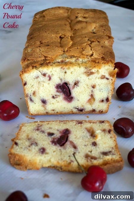 A large slice of Cherry Pound Cake on a white plate, showcasing the fluffy texture and ready to be enjoyed with a cup of tea or coffee.