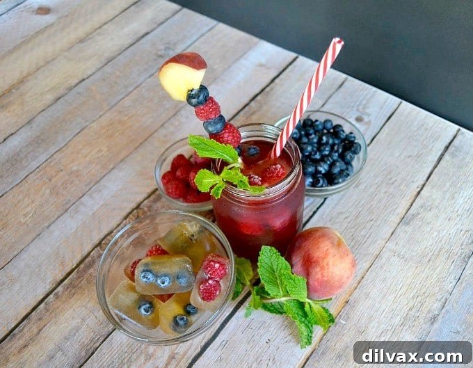 Vibrant Snapple Lady LiberTEA Raspberry Punch in a pitcher with fresh berries and mint, ready for summer parties.