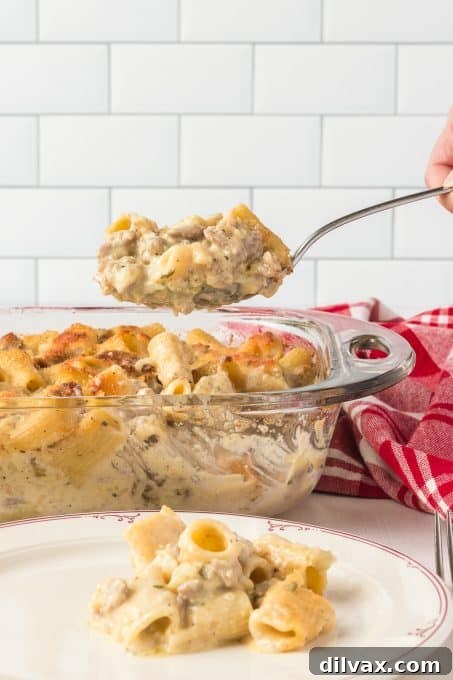 Creamy Sausage Alfredo Rigatoni 7 A spoonful of rigatoni with sausage and an Alfredo sauce, ready to eat.