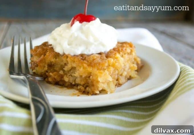 Pineapple Nectar Cake 4 A whole Pineapple Soak Cake garnished with whipped cream and pineapple wedges, showcasing its inviting appearance.