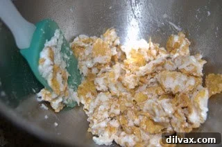Ingredients for Cornflake Macaroons being prepared, including egg white, sugar, coconut, and cornflakes.