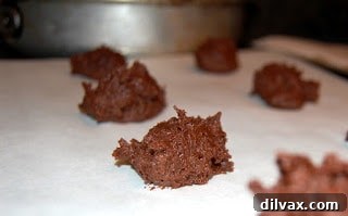 Cookie dough dropped onto parchment-lined baking sheet