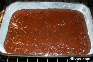 Brownie batter spread evenly in a baking pan.