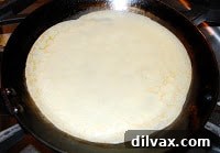 Freshly cooked crepe cooling on waxed paper.