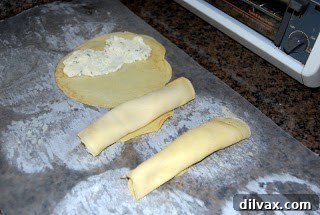 Rolled crepe filled with cheese, forming a manicotti.