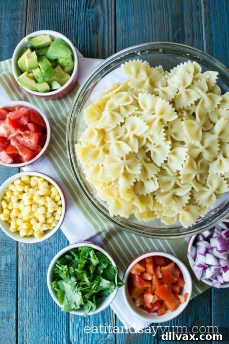 Southwest Fiesta Pasta Salad 3 A close-up of Tex-Mex Pasta Salad, showcasing the colorful ingredients like corn, red onion, bell pepper, and fresh cilantro, all coated in a zesty dressing.