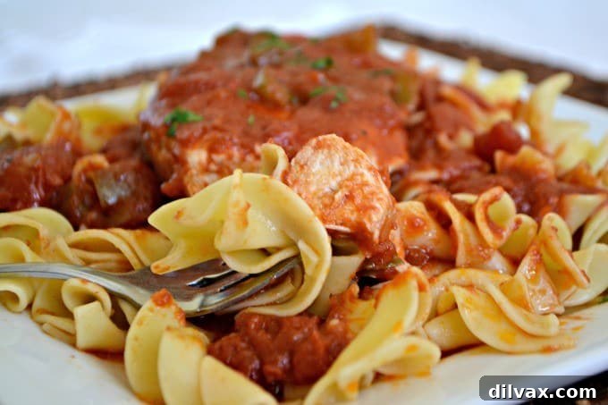 Classic Chicken Cacciatore, an easy skillet chicken dish with rich tomato sauce, vibrant green peppers, and savory onions. Perfect over noodles.