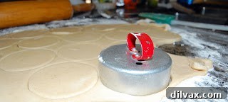 Cookie dough being rolled and cut into circles