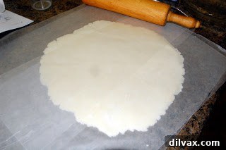 Rolling out gluten-free pie dough between wax paper
