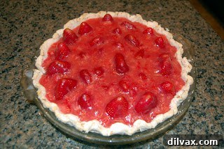 Strawberry glaze poured over the fresh berries in the pie