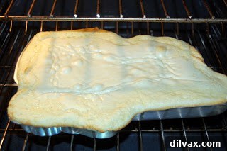 Cake batter poured into a baseball player shaped cake pan.