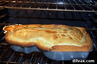 Cake baking in the oven, showing a slight rise.