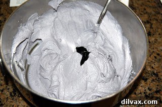 Unfrosted cake on a cake board, ready for decorating.