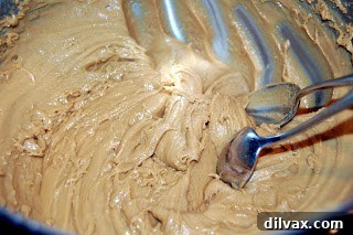 Mixing in sour milk and maple flavoring into cookie batter
