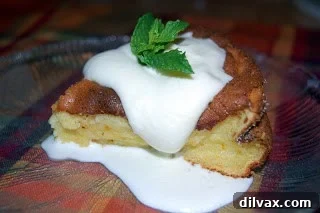 A serving of Orange Marmalade Soufflé with Grand Marnier sauce spooned over.