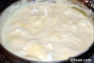 Gently folding the beaten egg whites into the soufflé base to maintain airiness.