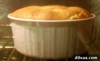 Soufflé baking in the oven, showing its impressive rise after 30 minutes.