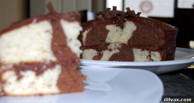 Close-up of a perfectly cut slice of marble cake, showcasing the beautiful interior swirls and a layer of chocolate frosting.