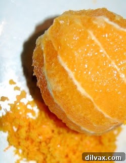 Orange slices arranged at the bottom of a muffin tin with honey.