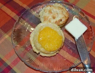 Baked Sticky Orange Muffins with caramelized orange slices on top.