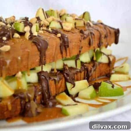 Close-up of a slice of Caramel Apple Pound Cake, showcasing layers of cake, apple, caramel, chocolate, and peanuts.