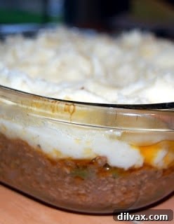Mashed potatoes spread over the meat filling, roughened with a fork.