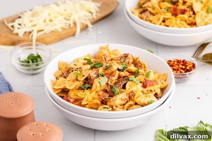 Melted Mozzarella Chicken Pasta 2 Chicken Mozzarella Pasta served in a bowl, showcasing creamy sauce, chicken, sun-dried tomatoes, and bacon.