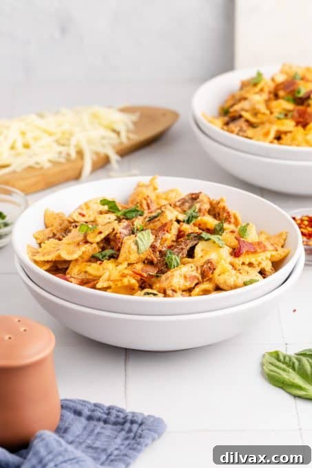 An easy chicken and pasta dinner served in a bowl, showcasing the creamy texture and vibrant ingredients.