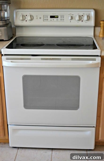 Close-up of a GE oven control panel and stovetop, showcasing modern kitchen appliances