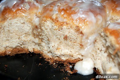 Close-up of a deliciously soft homemade cinnamon roll with generous, gooey glaze, ready to be enjoyed.