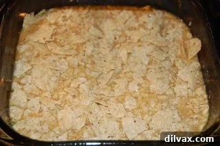 Day 21: Chile Cheese Casserole Magic 6 An additional layer of crushed tortilla chips placed on top of the casserole mixture in the baking pan.