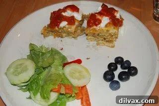 Day 21 Chile Cheese Casserole Delight 9 A slice of Chile Cheese Casserole served on a plate, garnished with a dollop of Greek yogurt and a side of salsa, ready for eating.