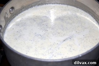 Infusing cream with vanilla bean for an aromatic Crème Brûlée base Cream and scraped vanilla bean after gentle boiling and steeping