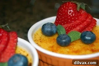 Beautifully garnished Crème Brûlée with fresh fruit and mint Crème Brûlée elegantly served with fresh berries and a sprig of mint