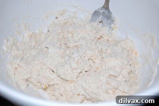 Adding milk to form biscuit dough