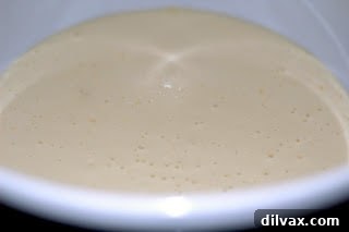 Close-up image of the wet kugel ingredients being blended in a food processor to a smooth consistency.